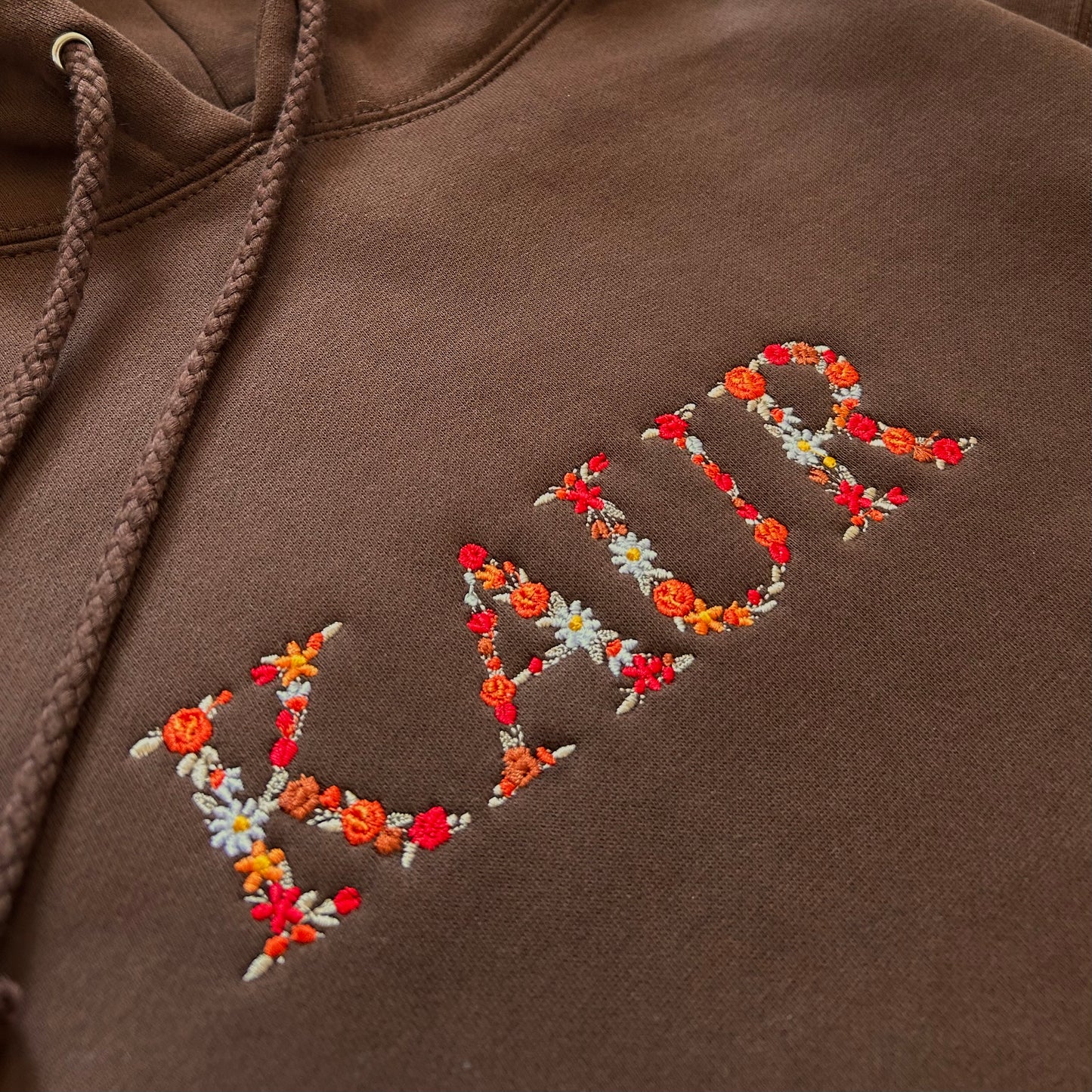 KAUR Hoodie Embroidered
KAUR hoodie with floral design on chest, artistic embroidery on dark fabric, Sikh-inspired apparel for women, Punjabi hoodie, empowering Kaur sweatshirt